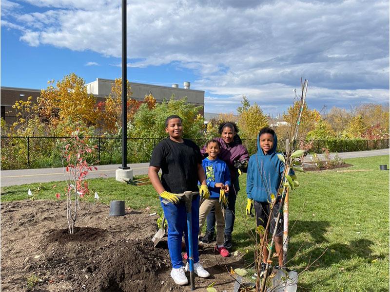 3 kids holding gardening equipment at oxford planting